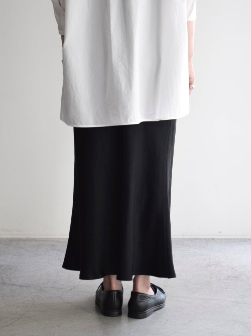 白のオーバーサイズシャツに黒のロングサテンフレアスカートのバックの着用画像