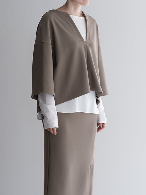 ...&DEAR グレージュのキーネック長袖プルオーバーと白ブラウスのレイヤードスタイル（斜め）