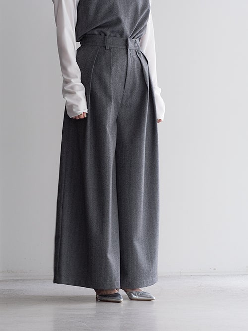 SALT+JAPAN（ソルトプラスジャパン）ウールワイドパンツの斜め着用画像。立体的なフロントタックと裾に向けて流れるきれいなドレープラインが際立つグレーのフレアシルエット。