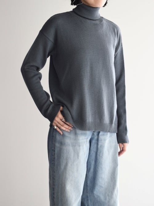 CROSSLEY（クロスリー）のグレー・タートルネックニットを着用した、斜め前からのスタイリング