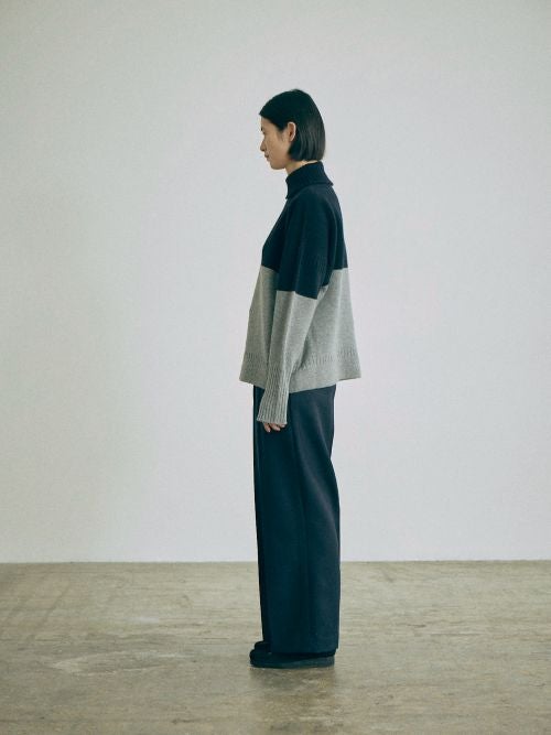 nicholson&nicholsonのバイカラーニット LULU-BI とパンツを合わせた、横からのシルエットや着丈バランスがわかるスタイリング画像