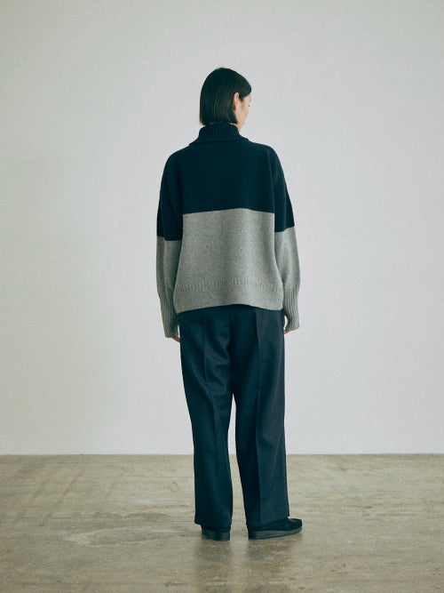 nicholson&nicholsonのバイカラーニット LULU-BI とパンツを合わせた、後ろ姿のシルエットや配色バランスがわかるスタイリング画像