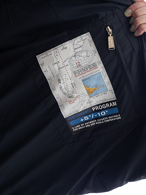 CAPE HORN ケープホーンのダウンジャケット「CORRALON」の内ポケットアップ。南米大陸の地図をモチーフにしたグラフィックタグと、対応気温（+5°/-10°）を示すパフォーマンスプログラムの表記。