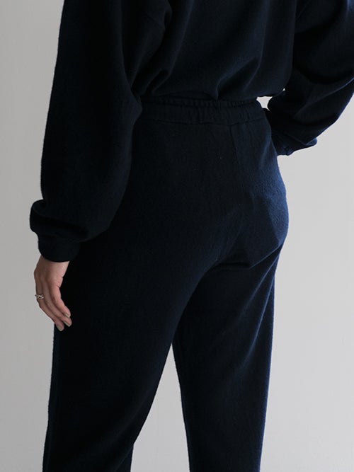 CROSSLEY クロスリー ネイビーのニットパンツ、ヒップ周りのバックスタイルを捉えた着用イメージ画像。すっきりとしたシルエットと上質な質感が際立つデザイン