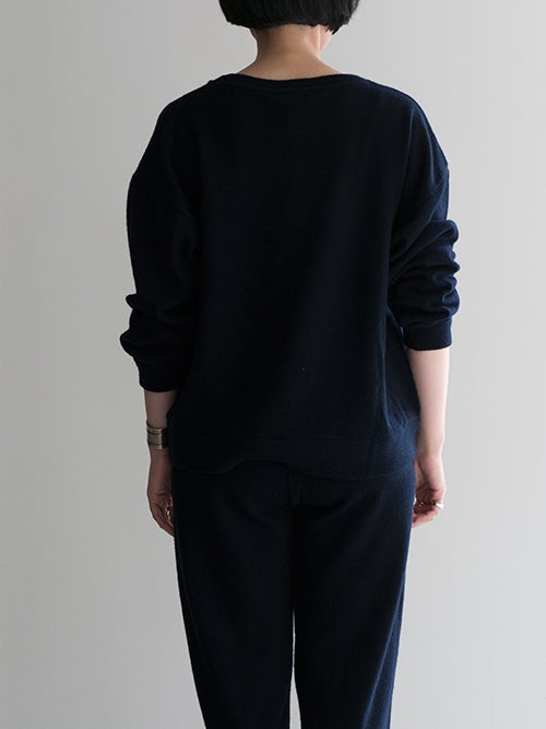 CROSSLEY クロスリー ネイビーのクルーネックニットソーを着用したバックスタイルのコーディネート画像。ヒップラインにかかる絶妙な着丈と、すっきりとした後ろ姿を演出する上品なシルエットが魅力のアイテム