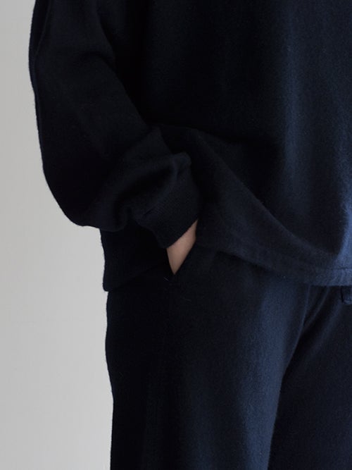 CROSSLEY クロスリー ネイビーのクルーネックニットソーとニットパンツのセットアップ着用画像、ポケットに手を入れたリラックス感のある着こなしを捉えたディテール