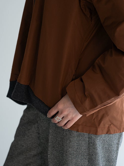 CROSSLEY ブルゾンの裾リブとグレーのボトムスの合わせのアップ